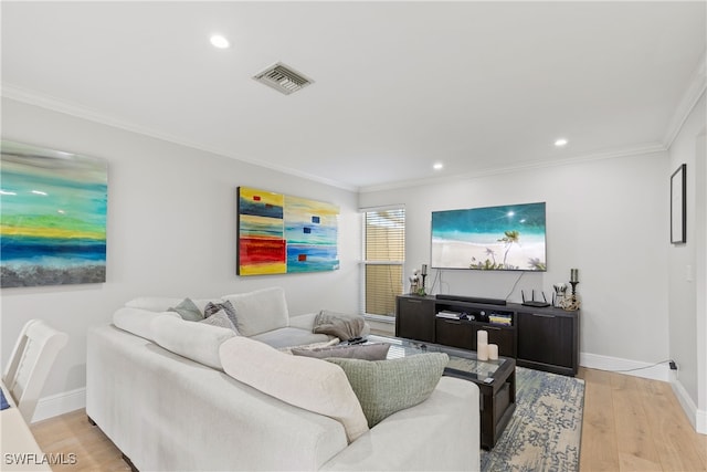living area with ornamental molding, baseboards, light wood-style floors, and visible vents