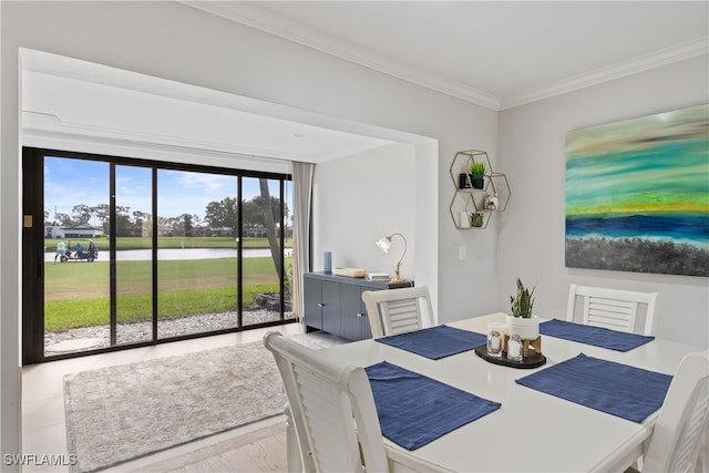 dining space featuring crown molding and a water view