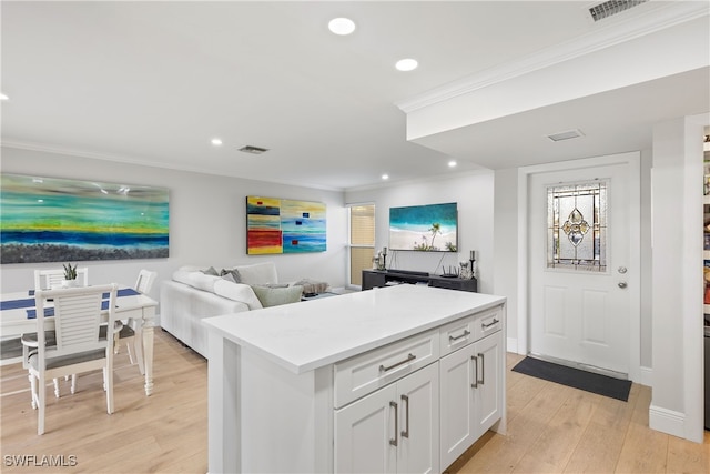 kitchen featuring white cabinetry, light countertops, crown molding, recessed lighting, and light wood-type flooring