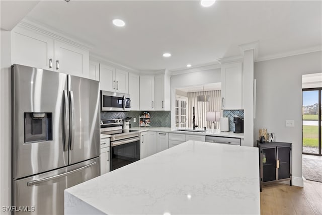 kitchen featuring white cabinetry, decorative backsplash, a sink, and stainless steel appliances