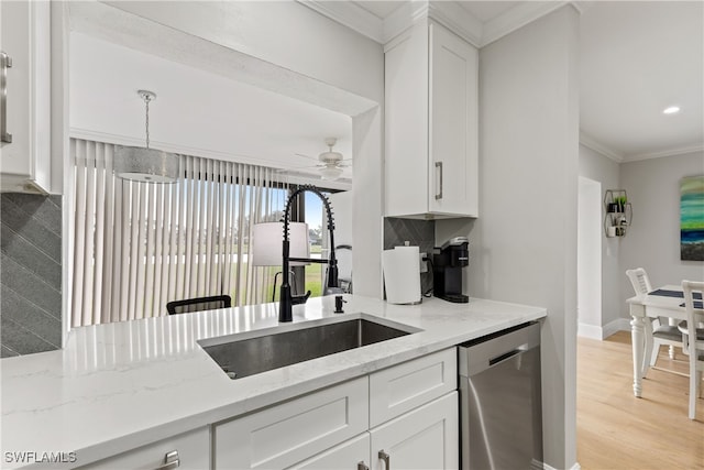 kitchen featuring crown molding, dishwasher, a ceiling fan, a sink, and light stone counters