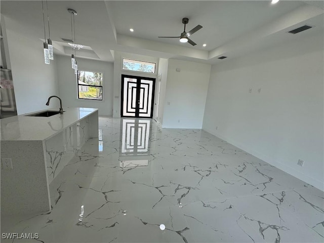 1173 Ebers St E, Lehigh Acres, FL 33974 - unfurnished living room with a tray ceiling, a ceiling fan, visible vents, a sink, and baseboards