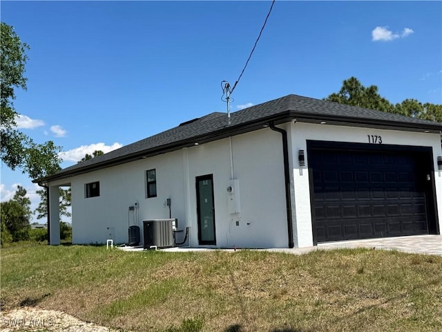 1173 Ebers St E, Lehigh Acres, FL 33974 - exterior space featuring a lawn, stucco siding, cooling unit, and an attached garage