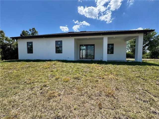 1173 Ebers St E, Lehigh Acres, FL 33974 - back of property featuring a yard and stucco siding