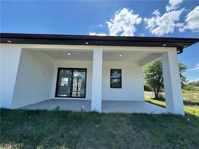 1173 Ebers St E, Lehigh Acres, FL 33974 - property entrance featuring stucco siding and a lawn