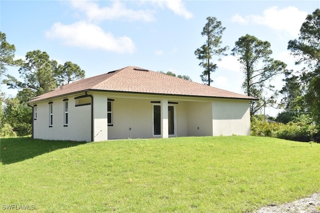 2515 45th St W, Lehigh Acres, FL 33971 - rear view of property featuring stucco siding, a lawn, and roof with shingles