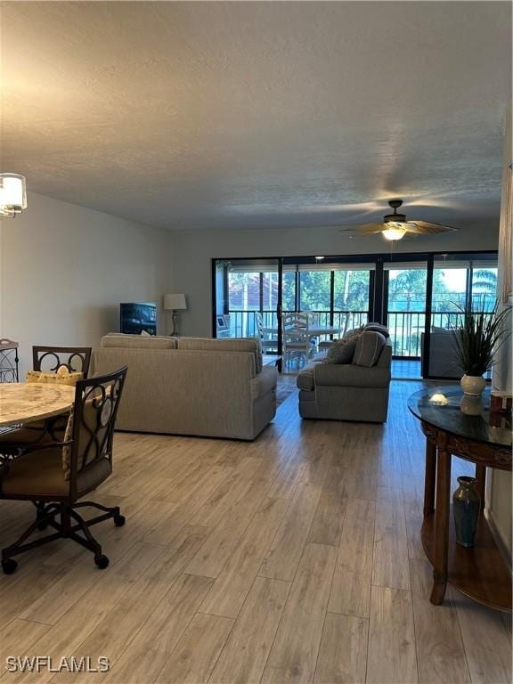 4244 SE 20th Pl Unit 218, Cape Coral, FL 33904 - living area featuring plenty of natural light, light wood-style flooring, ceiling fan, and a textured ceiling