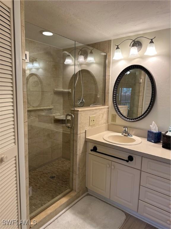 4244 SE 20th Pl Unit 218, Cape Coral, FL 33904 - bathroom with a shower stall, a closet, vanity, and a textured ceiling