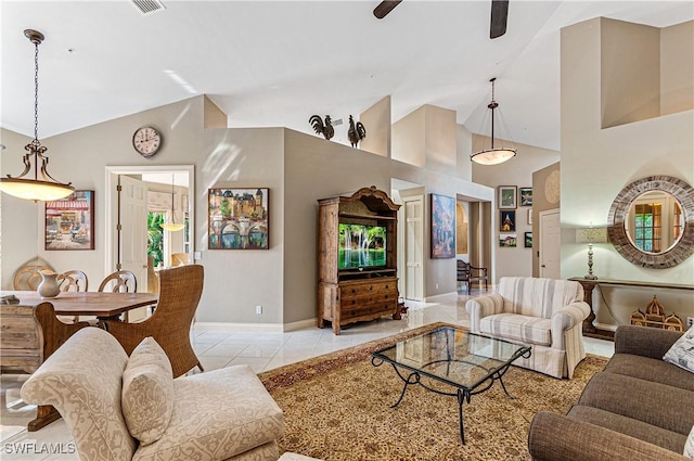 living area with light tile patterned floors, baseboards, ceiling fan, and high vaulted ceiling