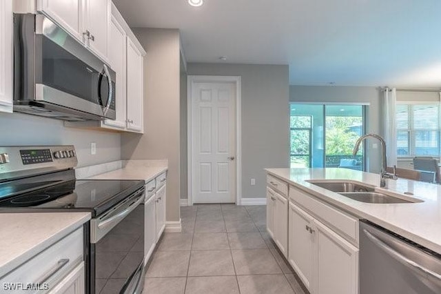 14566 Tropical Dr, Naples, FL 34114 - kitchen featuring light tile patterned floors, light countertops, white cabinets, stainless steel appliances, and a sink