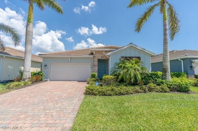 14566 Tropical Dr, Naples, FL 34114 - view of front of home with a front yard, decorative driveway, and an attached garage