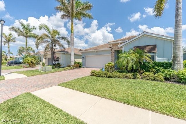 14566 Tropical Dr, Naples, FL 34114 - view of front facade with a front yard, a garage, and decorative driveway