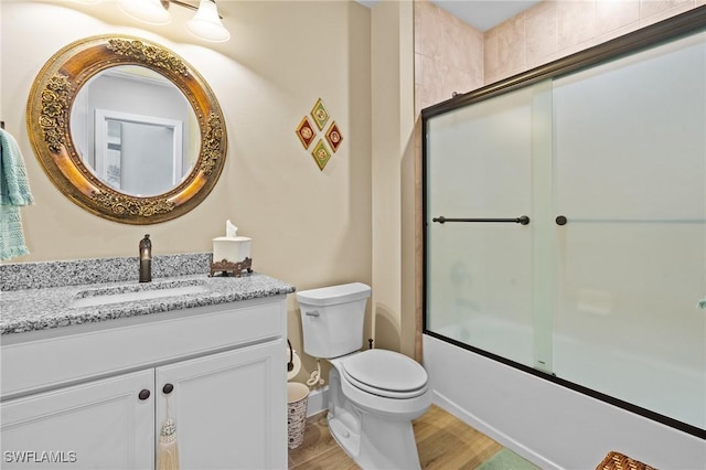 9435 Night Heron Ln, Naples, FL 34120 - bathroom featuring toilet, shower / bath combination with glass door, wood finished floors, and vanity