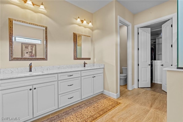 9435 Night Heron Ln, Naples, FL 34120 - bathroom with double vanity, toilet, baseboards, and a sink