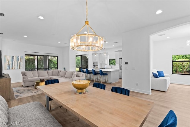 dining space with a chandelier, recessed lighting, and light wood-style flooring