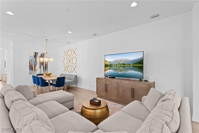 living area with an inviting chandelier, wood finished floors, and recessed lighting