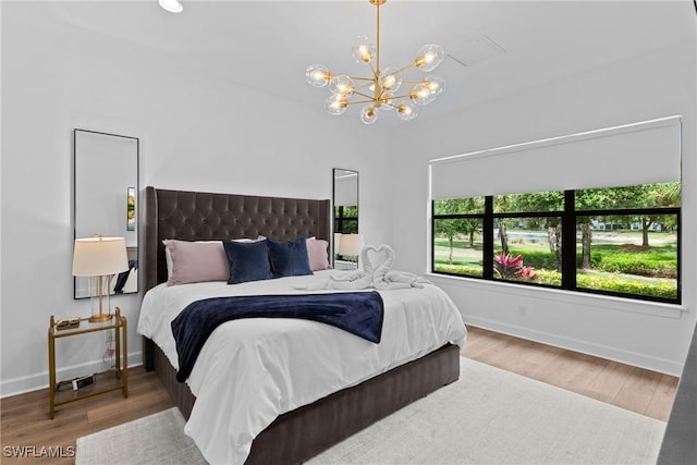 9336 Montelanico Loop, Naples, FL 34119 - bedroom featuring a chandelier, baseboards, and wood finished floors