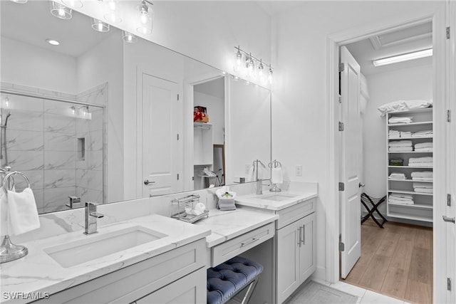 full bath with a walk in closet, a shower stall, and vanity