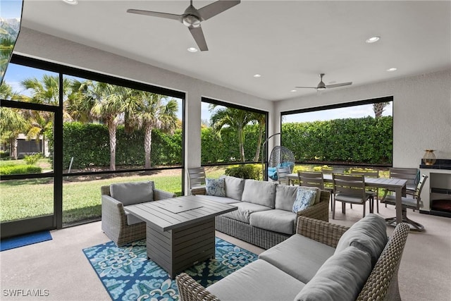 sunroom featuring outdoor lounge area, ceiling fan, and outdoor dining space