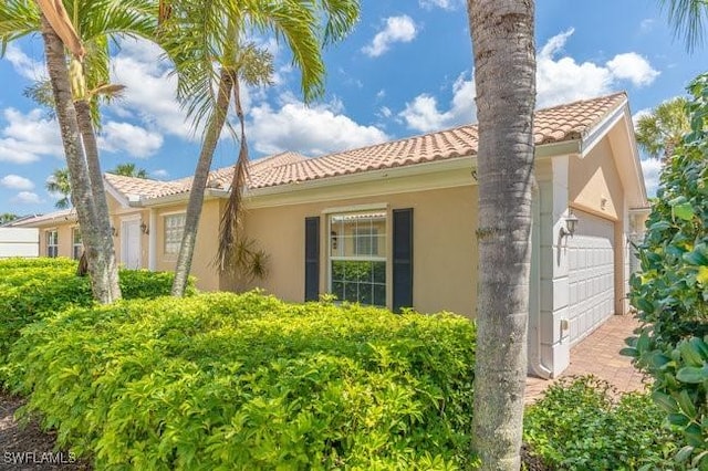 7857 Umberto Ct, Naples, FL 34114 - view of home's exterior with a garage, a tiled roof, and stucco siding