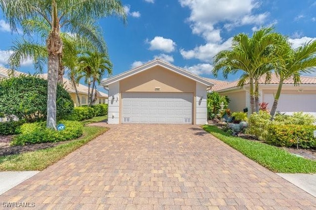 7857 Umberto Ct, Naples, FL 34114 - ranch-style home featuring stucco siding, an attached garage, and decorative driveway
