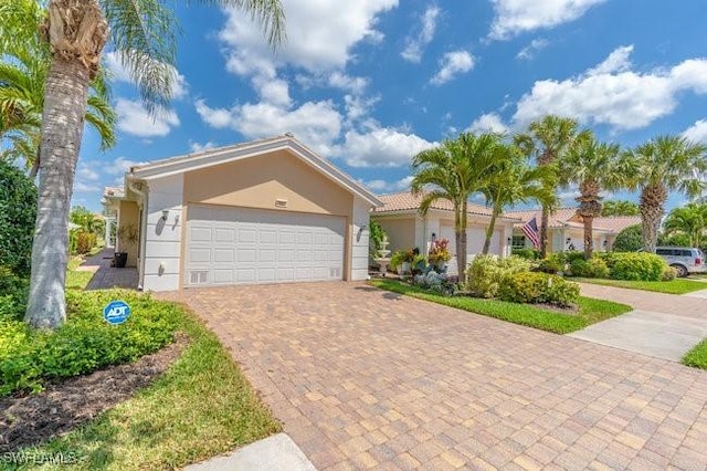 7857 Umberto Ct, Naples, FL 34114 - view of front facade featuring stucco siding, an attached garage, and decorative driveway