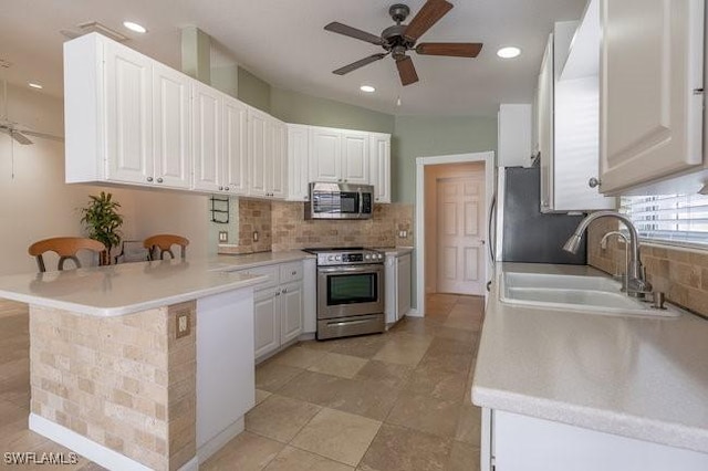 7857 Umberto Ct, Naples, FL 34114 - kitchen with a sink, a peninsula, tasteful backsplash, appliances with stainless steel finishes, and ceiling fan