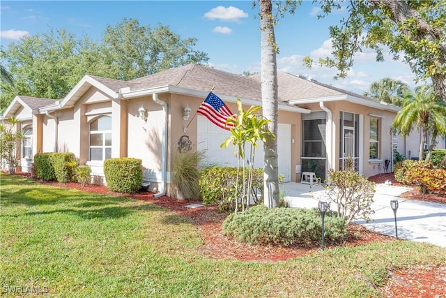 view of front of property featuring a front yard, concrete driveway, stucco siding, and an attached garage