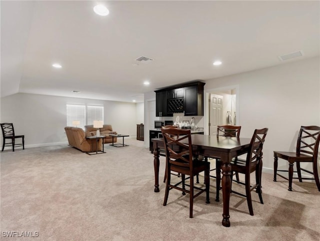 14016 Hawks Eye Ct, Estero, FL 33928 - dining room featuring light carpet, baseboards, visible vents, and indoor bar