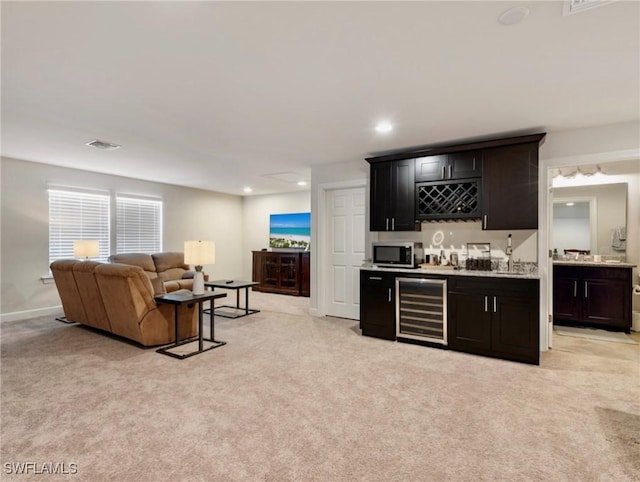 14016 Hawks Eye Ct, Estero, FL 33928 - bar with wine cooler, indoor wet bar, stainless steel microwave, light colored carpet, and visible vents