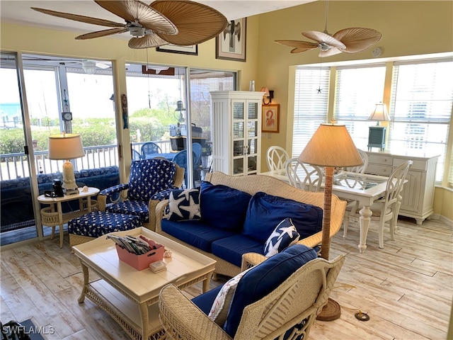 living area with light wood-type flooring and a ceiling fan