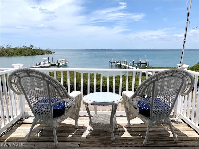 balcony with boat lift, a boat dock, and a water view