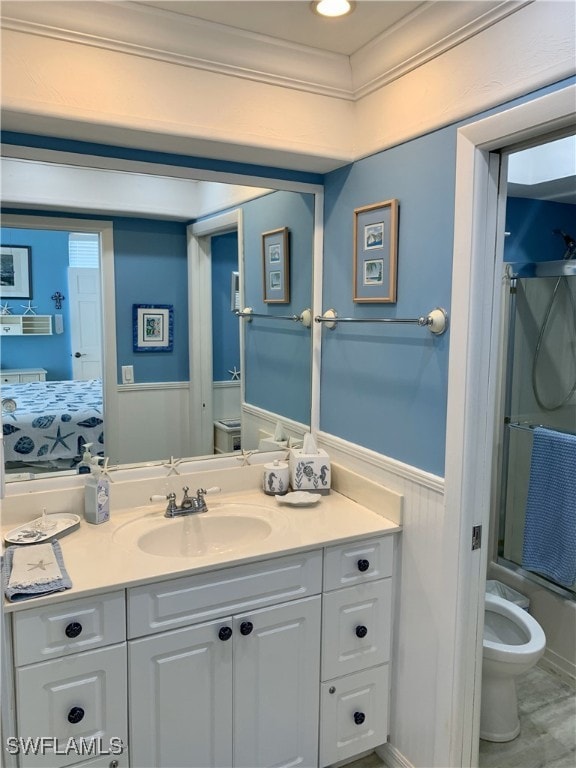 bathroom with vanity, crown molding, an enclosed shower, and toilet