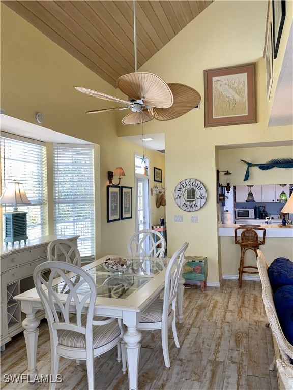 dining area featuring light wood finished floors, ceiling fan, a healthy amount of sunlight, and wooden ceiling