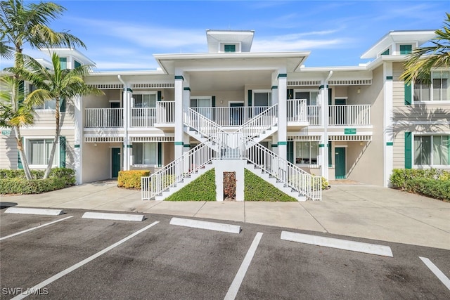 7920 Mahogany Run Ln Unit 1015, Naples, FL 34113 - view of building exterior featuring stairway and uncovered parking