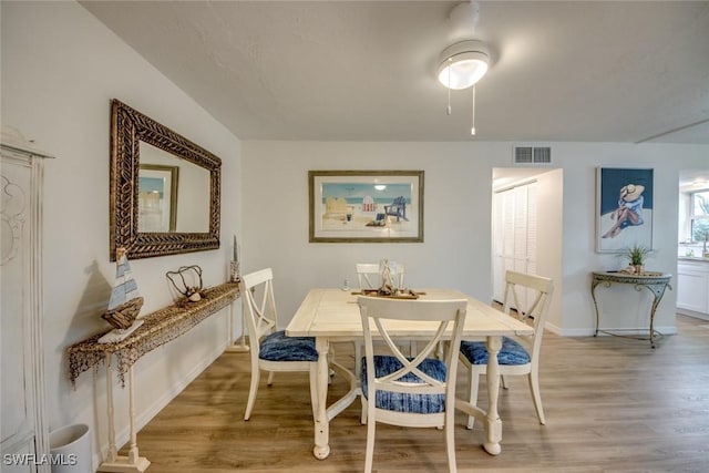 dining room featuring visible vents, light wood-style flooring, and baseboards