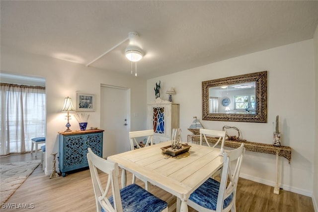 dining area with light wood-type flooring and baseboards