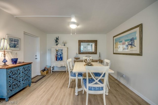 dining space featuring light wood-style floors and baseboards