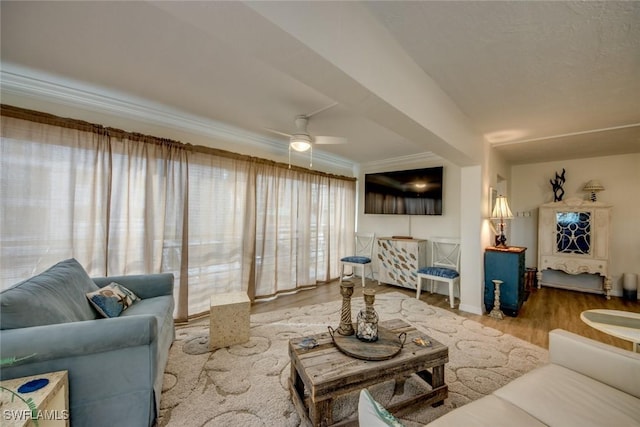 living room featuring crown molding, baseboards, a ceiling fan, and wood finished floors