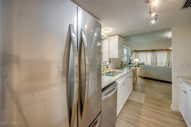 kitchen featuring a sink, white cabinetry, visible vents, and stainless steel appliances