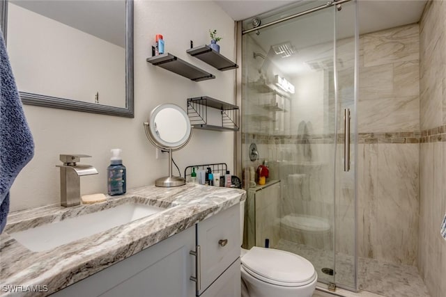 full bath featuring a shower stall, vanity, and toilet