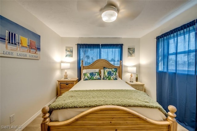 bedroom with ceiling fan, baseboards, and multiple windows