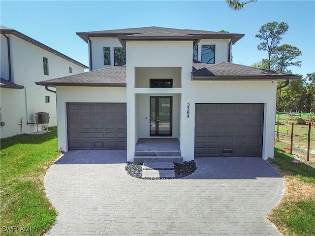 3384 Canal St, Naples, FL 34112 - view of front of house featuring an attached garage, stucco siding, driveway, and french doors