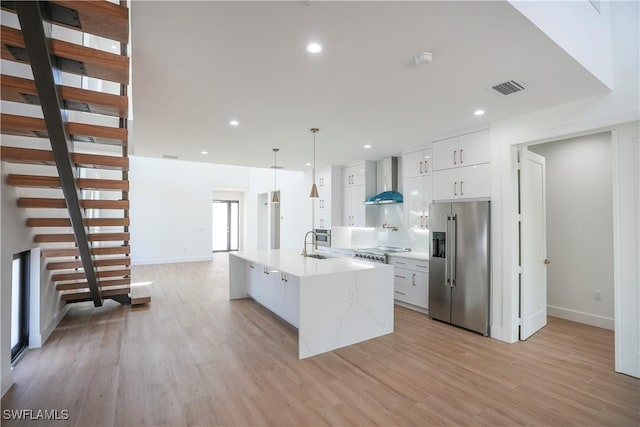 3384 Canal St, Naples, FL 34112 - kitchen with light wood finished floors, wall chimney exhaust hood, visible vents, and appliances with stainless steel finishes