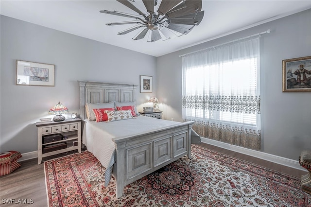 bedroom featuring baseboards, a ceiling fan, and wood finished floors