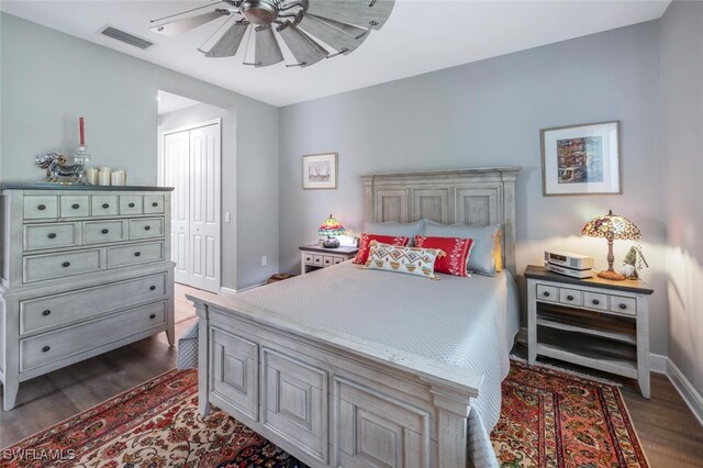 bedroom featuring visible vents, baseboards, a closet, ceiling fan, and dark wood-type flooring