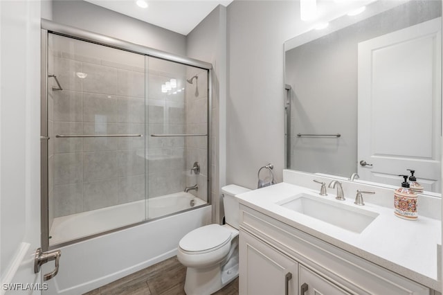 full bathroom with shower / bath combination with glass door, vanity, recessed lighting, toilet, and wood finished floors