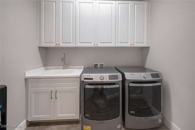 laundry room with washing machine and dryer, baseboards, a sink, and cabinet space