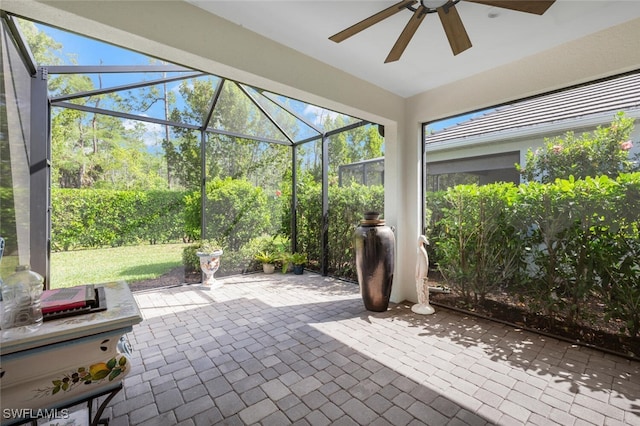 view of patio / terrace featuring ceiling fan and glass enclosure
