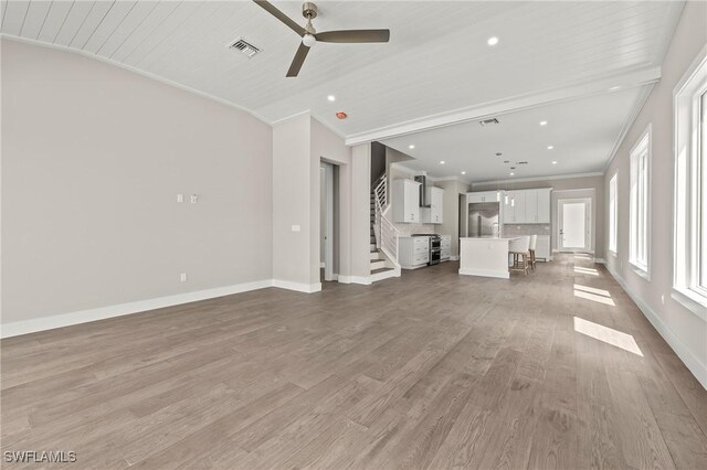 1134 Trail Terrace Dr, Naples, FL 34103 - unfurnished living room featuring crown molding, lofted ceiling, light wood finished floors, visible vents, and a ceiling fan